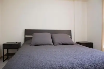 a bedroom with a bed with two pillows on it at Galatex Beach Apartment in Limassol