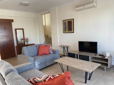 a living room with a couch and a tv at Villas Ithaca Protaras in Protaras