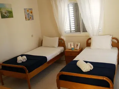 two twin beds in a room with a window at Villas Ithaca Protaras in Protaras