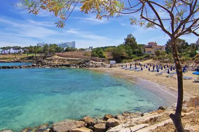 a beach with a bunch of chairs and the water at Apartment Victoria in Protaras