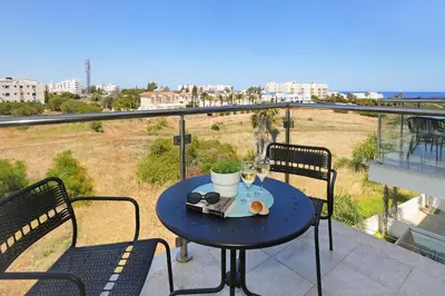a table on a balcony with a view of the ocean at Apartment Victoria in Protaras