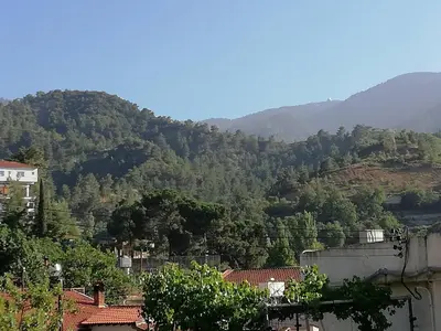 a view of a mountain with trees and buildings at Christos House in Kakopetria