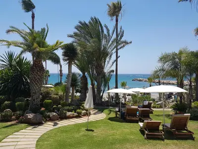 a resort with chairs and umbrellas and the ocean at Alania Sea View Apartment in Limassol