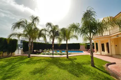 a yard with palm trees and a swimming pool at Villa Eva in Ayia Napa
