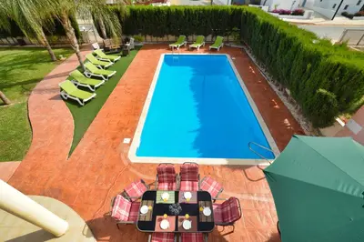 a swimming pool with lounge chairs and an umbrella at Villa Eva in Ayia Napa