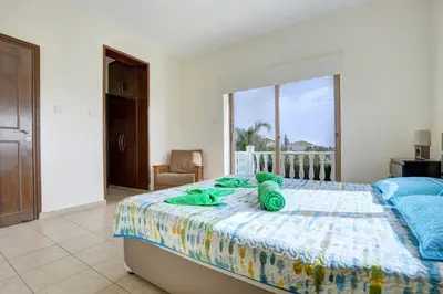 a teddy bear laying on a bed in a bedroom at Villa Eva in Ayia Napa