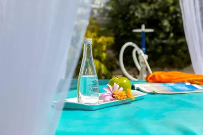 a table with a bottle of water and fruit on it at Fig Tree Bay Villa 3 in Protaras