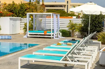 a group of lounge chairs next to a swimming pool at Fig Tree Bay Villa 3 in Protaras