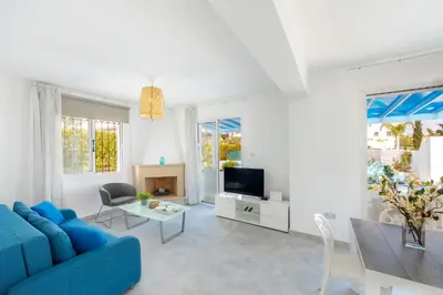 a living room with a blue couch and a table at Fig Tree Bay Villa 3 in Protaras