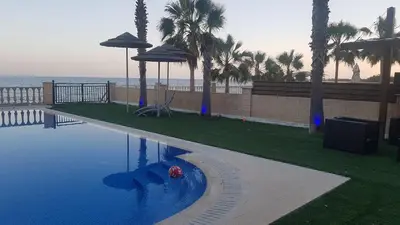 a pool with a ball in the water and palm trees at Oasi Rejuve Villa in Meneou