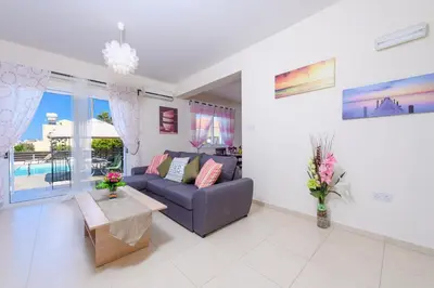 a living room with a couch and a table at Sunset Villa Protaras in Protaras