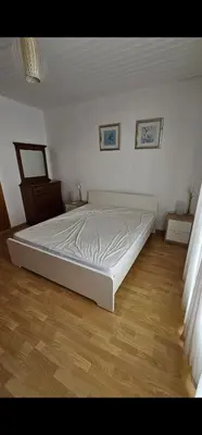 a white bed in a room with a wooden floor at Luxury Apartment Ayia Napa Center in Ayia Napa