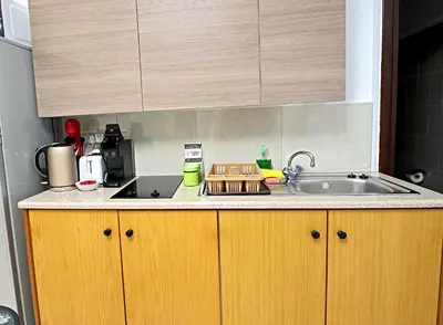 a kitchen with wooden cabinets and a sink at Pieris Apartments in Ayia Napa