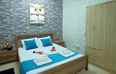 a bedroom with a large bed with blue pillows at Pieris Apartments in Ayia Napa