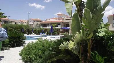 a resort with a swimming pool and some plants at Pyla Gardens A101 in Pyla