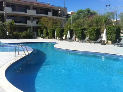 a swimming pool with blue water in a hotel at Pyla Gardens A101 in Pyla