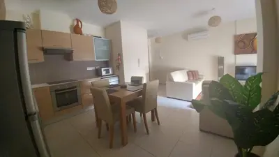 a kitchen and dining room with a table and chairs at Pyla Gardens A101 in Pyla