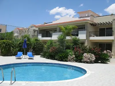 a swimming pool in front of a building at Pyla Gardens A101 in Pyla