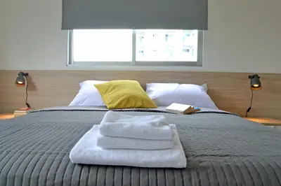 a bed with towels on top of it with a window at Athena Holiday Homes in Limassol