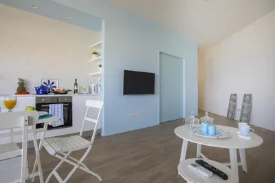 a kitchen and living room with a table and chairs at Azure Beachfront Suite in Protaras