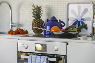 a kitchen counter with a bowl of fruit and vegetables at Azure Beachfront Suite in Protaras