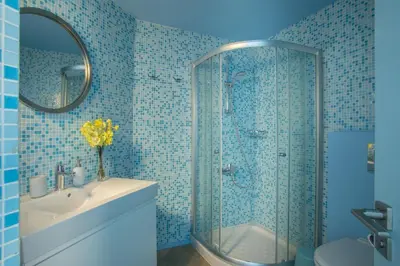 a bathroom with a shower and a sink and a mirror at Azure Beachfront Suite in Protaras