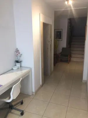a hallway with a desk and a chair and stairs at Nautilus Tourist Apartments in Larnaka