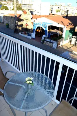 a glass table with a vase of flowers on a balcony at Cross Road in Ayia Napa