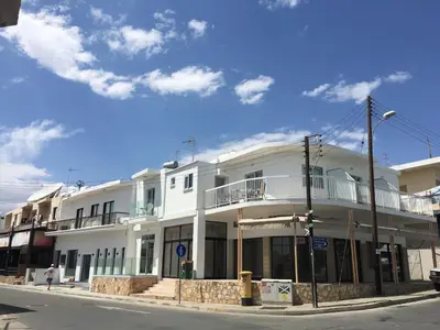 a white building on the corner of a street at Cross Road in Ayia Napa