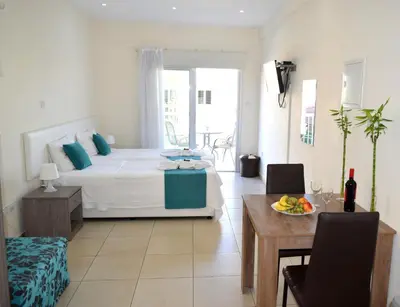 a bedroom with a bed and a table with a plate of fruit at Cross Road in Ayia Napa