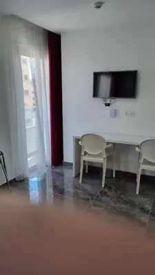a room with two chairs and a table and a tv at Art & Wine Boutique Hotel in Larnaka