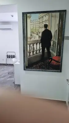 a painting of a man standing on a balcony at Art & Wine Boutique Hotel in Larnaka