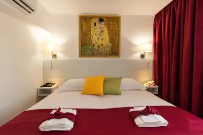 a bedroom with a large bed with red curtains at Art & Wine Boutique Hotel in Larnaka