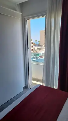 a bedroom with a large window with a view at Art & Wine Boutique Hotel in Larnaka