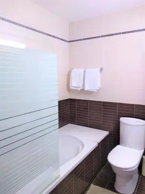 a bathroom with a toilet and a tub and a sink at T&E Apartment in Larnaka