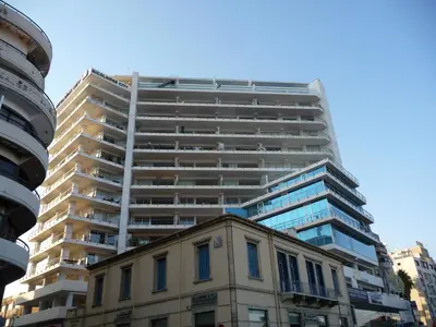 a tall apartment building in front of a building at T&E Apartment in Larnaka