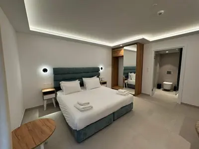 a bedroom with a large white bed and a table at Hypnos Boutique Hotel in Nicosia