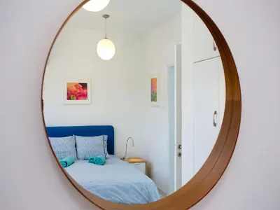 a mirror in a bedroom with a bed at On The Beach Penthouse by TrulyCyprus in Limassol