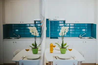 a kitchen with two tables with glasses of wine and flowers at Stephanie Studios in Larnaka