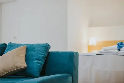 a blue couch with a pillow next to a table at Stephanie Studios in Larnaka