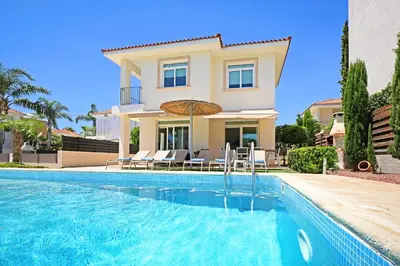 a villa with a swimming pool in front of a house at Villa Celine in Protaras