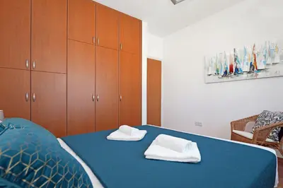a bedroom with a blue bed with towels on it at Villa Celine in Protaras
