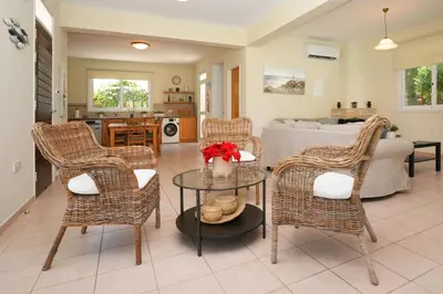 a living room with wicker chairs and a table at Villa Celine in Protaras