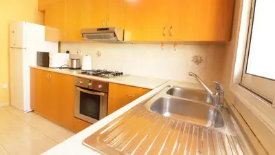 a small kitchen with a sink and a stove at Panikos Beach Apartment I in Larnaka