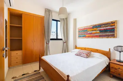 a bedroom with a bed and a painting on the wall at CityDen in Larnaka