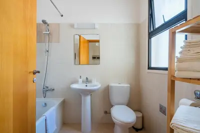 a bathroom with a toilet and a sink and a bath tub at CityDen in Larnaka