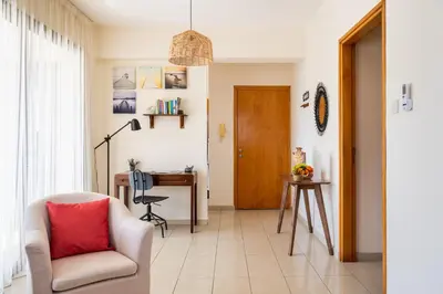a living room with a chair and a desk at CityDen in Larnaka