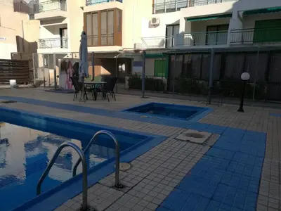 a swimming pool in front of a building at Siamese Villa in Paralimni
