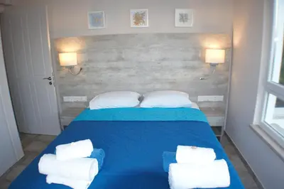 a bedroom with a blue bed with towels on it at Periyiali Beach Sunset Suite A7 in Pervolia