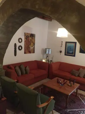 a living room with a red couch and a table at Villa Thermopilon in Larnaka